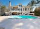 Beautiful backyard featuring a pool, lush trees and a stone patio, great for relaxing or entertaining at 709 Prestige Pt, Peachtree City, GA 30269