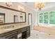 Luxurious bathroom featuring a soaking tub, chandelier, and vanity with a granite countertop at 709 Prestige Pt, Peachtree City, GA 30269