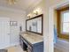 Bathroom vanity featuring granite countertop, dark wood cabinets, and decorative mirror at 709 Prestige Pt, Peachtree City, GA 30269