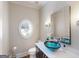 Stylish powder room features a unique glass sink, decorative mirror, and oval stained glass window at 709 Prestige Pt, Peachtree City, GA 30269