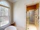 Bright bathroom featuring a glass door shower and a soaking tub in front of a window at 709 Prestige Pt, Peachtree City, GA 30269