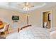 Bedroom with a bed, desk, TV, and a view to the en suite bathroom in a bright room at 709 Prestige Pt, Peachtree City, GA 30269