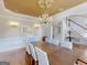 Elegant dining room with a chandelier, dark wood table, and wainscoting detail, with an archway visible at 709 Prestige Pt, Peachtree City, GA 30269
