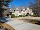 Beautiful two-story home with stone and stucco exterior, a long driveway, and landscaped yard at 709 Prestige Pt, Peachtree City, GA 30269
