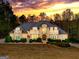 Beautiful two-story home with stone and stucco exterior against a colorful sunset backdrop at 709 Prestige Pt, Peachtree City, GA 30269