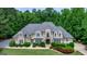Stately home featuring stone and stucco exterior, lush landscaping, and a circular driveway at 709 Prestige Pt, Peachtree City, GA 30269