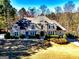 Two-story home with manicured lawn, stone and stucco exterior, and mature trees at 709 Prestige Pt, Peachtree City, GA 30269