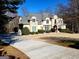 Beautiful two-story home with a long driveway, stone accents, and mature landscaping at 709 Prestige Pt, Peachtree City, GA 30269