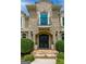 Close-up of the front entrance featuring a stone facade, wrought-iron details, and manicured greenery at 709 Prestige Pt, Peachtree City, GA 30269