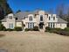 Elegant two-story home featuring a stone and stucco exterior, a well-manicured lawn, and lovely landscaping at 709 Prestige Pt, Peachtree City, GA 30269
