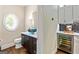Stylish half bathroom boasts unique round window, vessel sink, and convenient beverage center at 709 Prestige Pt, Peachtree City, GA 30269