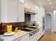 Updated kitchen features stainless steel appliances, custom backsplash, and white cabinets at 709 Prestige Pt, Peachtree City, GA 30269