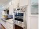 Modern kitchen featuring stainless steel appliances, marble countertops, and sleek white cabinets at 709 Prestige Pt, Peachtree City, GA 30269