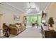 Bright living room features a cozy couch, desk, and bay windows with natural light at 709 Prestige Pt, Peachtree City, GA 30269