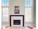 Bright living room featuring a fireplace with white stone and natural light from large windows at 709 Prestige Pt, Peachtree City, GA 30269