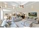 Spacious living room with plush gray sofas, high ceilings, and an open floor plan to kitchen and dining at 709 Prestige Pt, Peachtree City, GA 30269