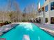 An inviting backyard pool area with a diving board and surrounded by meticulously manicured landscaping at 709 Prestige Pt, Peachtree City, GA 30269