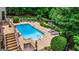 Backyard view with large in-ground pool, lush greenery, and a deck for relaxing and entertaining at 709 Prestige Pt, Peachtree City, GA 30269