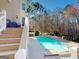 Inviting backyard pool with clear blue water, surrounded by lush landscaping and stairs to the home at 709 Prestige Pt, Peachtree City, GA 30269