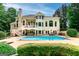 Back of house view with large pool, patio, manicured greenery, and an eye-catching exterior design at 709 Prestige Pt, Peachtree City, GA 30269