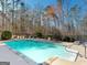 Sparkling backyard pool with a clear blue water surrounded by well-maintained landscaping at 709 Prestige Pt, Peachtree City, GA 30269