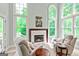 Cozy sitting area with fireplace, plush armchairs, and large windows providing ample natural light at 709 Prestige Pt, Peachtree City, GA 30269