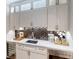 Updated wet bar showcases white cabinets, marble counters, stainless steel appliances, and a wine cooler at 709 Prestige Pt, Peachtree City, GA 30269