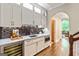 Wet bar featuring a wine fridge, dark backsplash, white cabinets, and marble countertop at 709 Prestige Pt, Peachtree City, GA 30269