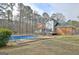 Spacious backyard with a refreshing swimming pool, wooden deck, screened porch, and lush greenery at 185 Lady Helen Ct, Fayetteville, GA 30214