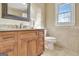 Bathroom features include a vanity with granite countertop, decorative mirror, and a toilet next to a window at 185 Lady Helen Ct, Fayetteville, GA 30214