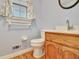 Bathroom featuring a white toilet, wooden vanity with sink, decorative curtains and light blue walls at 185 Lady Helen Ct, Fayetteville, GA 30214