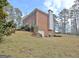 Brick two-story home with a two-car garage and green shutters surrounded by trees on a sunny day at 185 Lady Helen Ct, Fayetteville, GA 30214