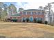 Two story brick home with green roof, white windows and a turquoise front door with mature landscaping at 185 Lady Helen Ct, Fayetteville, GA 30214