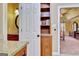 Hallway featuring built in shelves and bathroom view, leading to a bedroom with warm colors at 185 Lady Helen Ct, Fayetteville, GA 30214