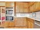 A kitchen boasting warm wooden cabinetry, stainless steel double ovens, and light countertops at 185 Lady Helen Ct, Fayetteville, GA 30214