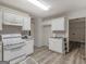 Bright kitchen with white appliances, ample cabinet space and wood-look flooring at 3623 Meadow Glen Cir, Ellenwood, GA 30294