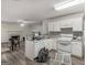 An open-concept kitchen featuring white cabinetry, appliances, and wood-look flooring at 3623 Meadow Glen Cir, Ellenwood, GA 30294