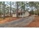 Side view of a well-maintained house with a concrete driveway, nestled in a serene, wooded setting at 949 Rock Oak Ln, Lawrenceville, GA 30046