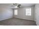 Spacious bedroom featuring neutral walls, soft carpet, a ceiling fan, and natural light from two windows at 3049 Flat Shoals Rd, Atlanta, GA 30349