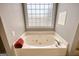 Close up on bathroom tub that features jacuzzi jets and glass block window at 2683 Mariner Way, Villa Rica, GA 30180