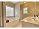 Bathroom with a large tub, double sinks, and natural light from multiple windows at 2683 Mariner Way, Villa Rica, GA 30180