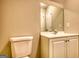 Well-lit bathroom featuring a toilet, vanity with mirror, and cabinet storage at 2683 Mariner Way, Villa Rica, GA 30180