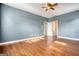 Bright bedroom featuring hardwood floors, ceiling fan, and entrance into the ensuite bathroom at 2683 Mariner Way, Villa Rica, GA 30180