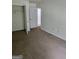 This carpeted bedroom features a closet and a white door at 2764 Keystone Ave, Lithonia, GA 30058