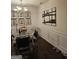 Dining room boasts a glass table, chandelier, dark wood floors, and elegant butterfly wall art, perfect for entertaining at 2764 Keystone Ave, Lithonia, GA 30058
