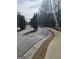 The property entrance features a gated entry, mature trees, and a curved sidewalk at 2764 Keystone Ave, Lithonia, GA 30058