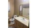 A bathroom with a tan vanity and mirror, plus a toilet and shower at 2400 Reynolds Sw Rd, South Fulton, GA 30331