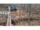 An aerial view of a two-story home, surrounded by mature trees and a small stream and bridge at 613 Rock Springs Pass, Dallas, GA 30157