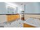 Bathroom with a bathtub, wooden cabinets, a large mirror, and blue wall accents at 613 Rock Springs Pass, Dallas, GA 30157