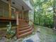 Inviting porch featuring wooden stairs, decorative railings, and lush greenery, creating a tranquil entry at 613 Rock Springs Pass, Dallas, GA 30157